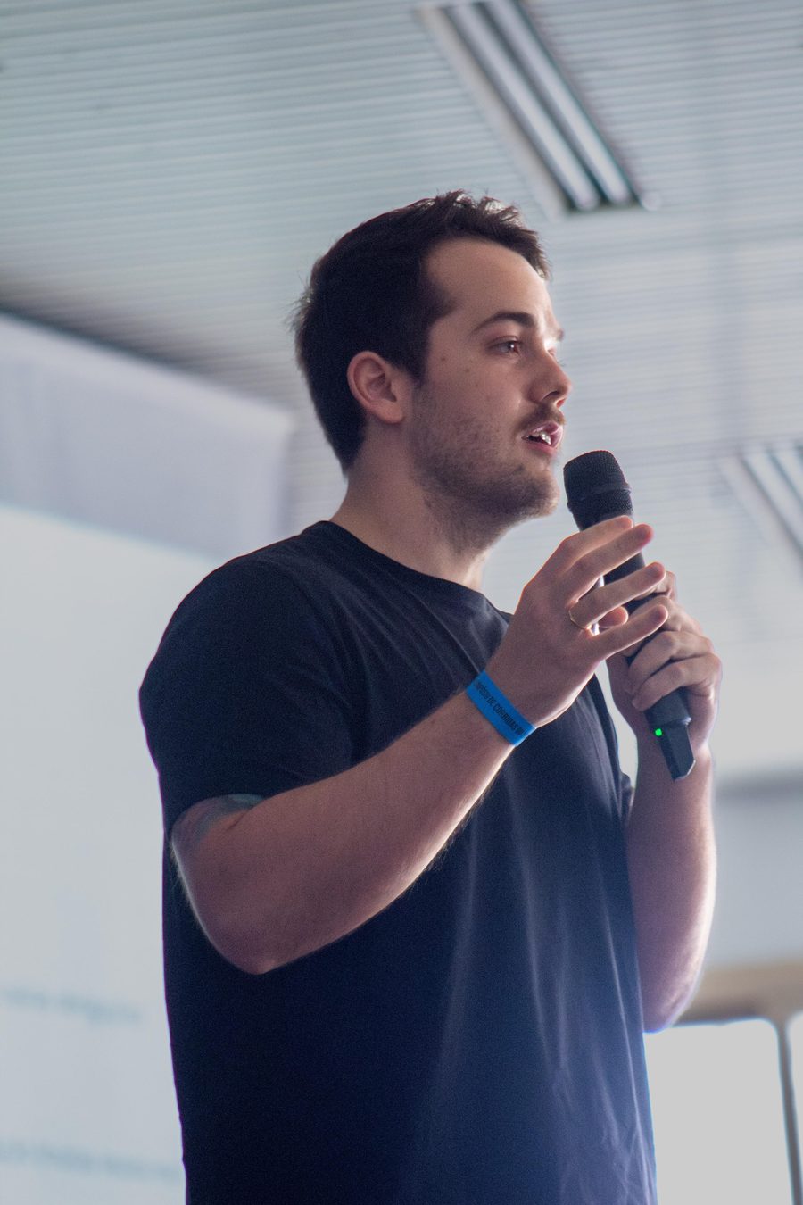 Ariel Murlik palestrando sobre psicologia do esporte, com microfone na mão